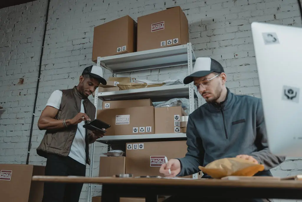 Two warehouse employees organising and packing parcels for delivery in a modern indoor setting.